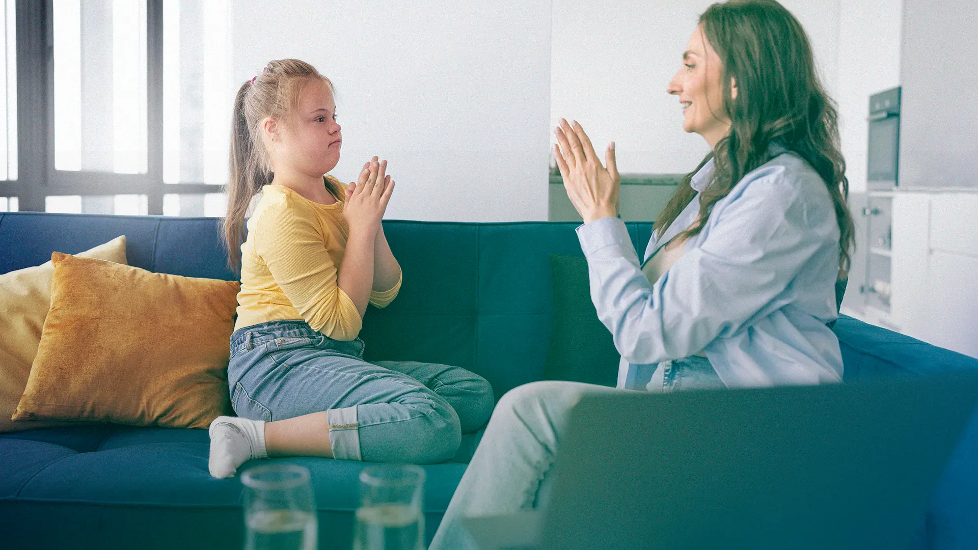 Criança com necessidades especiais interagindo com uma profissional em atividade de estímulo e aprendizagem.