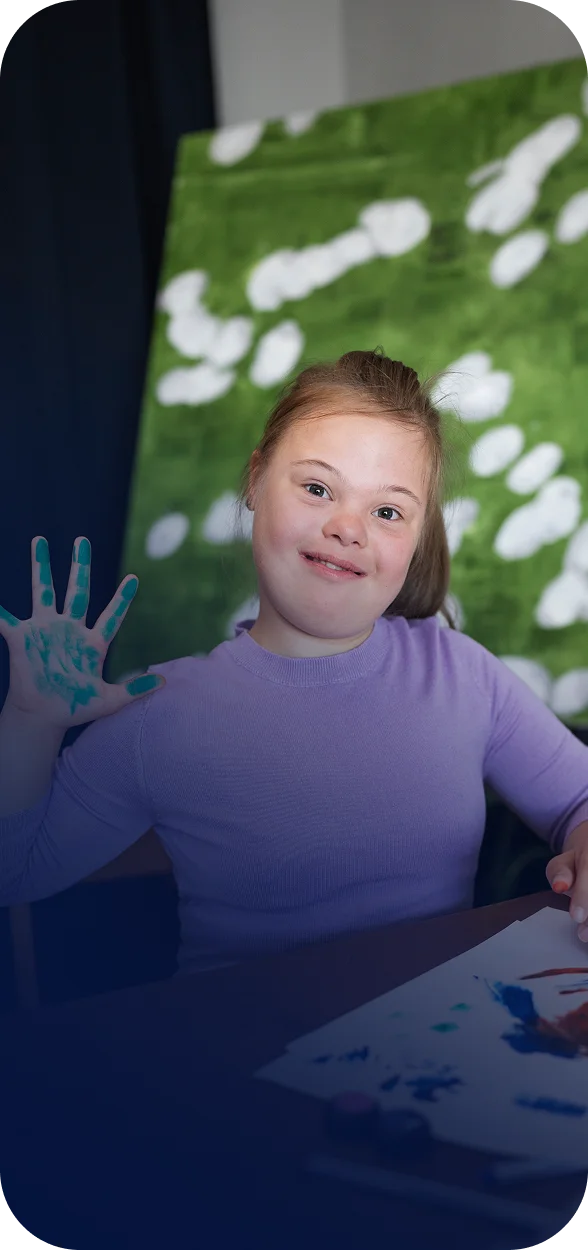 Criança com necessidades especiais a pintar, em momento de lazer e estímulo criativo.